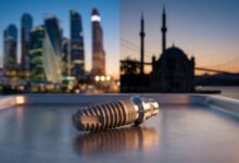 A close-up, photorealistic image of a high-quality titanium dental implant in sharp focus. The background is artistically split and blurred, showing a modern American cityscape on one side and the historic Istanbul skyline on the other, representing the choice in dental tourism locations.