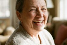 A close-up photograph of a joyful senior woman with a perfect, healthy smile, illustrating the confidence gained from modern dental solutions like implants.