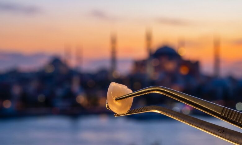 A close-up, photorealistic image of a perfect white zirconia dental crown held by tweezers, with the sun setting over a heavily blurred background of the Istanbul, Turkey skyline and the Bosphorus.
