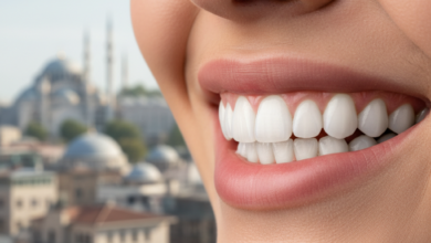 Close-up of a person smiling, showing a perfect set of white, even teeth that represent dental veneers. The background is softly blurred, revealing a generic Turkish cityscape with architectural elements like domes or minarets under a bright sky.