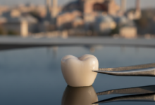 A close-up, photorealistic view of a pristine, natural-looking dental crown, showcasing its intricate details and a lifelike translucency, set against a softly blurred background depicting the architectural grandeur of Istanbul, Turkey.