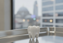 A photorealistic, detailed close-up of a perfectly white and natural-looking dental crown, positioned on a clean, reflective surface. The background is softly blurred, showing hints of a modern dental clinic setting with bright, professional lighting, subtly suggesting an international medical destination.