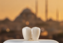 A photorealistic, ultra-detailed close-up of a single, flawless dental crown, appearing to be made of high-quality ceramic material like zirconia or E-max. The crown is in sharp focus, resting on a sterile, minimalist surface, showcasing its natural translucency and shape. In the soft, out-of-focus background, a warm-toned, indistinct silhouette of a Turkish city skyline, possibly Istanbul, is visible under a gentle light. There is no text present in the image.