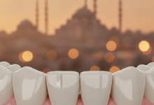 Close-up, photorealistic image showcasing perfectly aligned, brilliant white dental crowns, representing high-quality dental restoration and a natural-looking smile. In the softly blurred background, a modern Turkish cityscape with iconic architectural outlines, bathed in warm golden hour light. The image uses cinematic lighting and shallow depth of field, with no visible text or people.