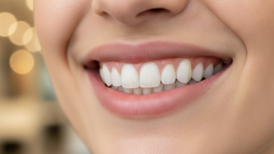 Close-up of a person smiling brightly, revealing perfectly aligned, natural-looking white teeth that suggest successful dental crown treatment. The background is a softly blurred, modern dental clinic environment.