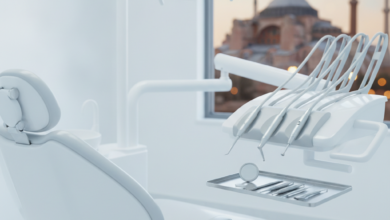 A modern, sterile dental clinic interior with a sleek, empty dental chair and high-tech dental instruments on a tray in the foreground. Through a large, blurred window in the background, a recognizable, out-of-focus Turkish landmark like the Hagia Sophia or a mosque's minaret, overlooking the Bosphorus, is visible. The lighting is bright and cinematic, emphasizing cleanliness and the fusion of dental care with tourism. No text or visible branding.