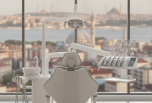 A modern, bright dental clinic with a pristine white dental chair and advanced equipment in the foreground. Through a large window in the background, a blurred but identifiable cityscape of Istanbul, Turkey, with its distinctive minarets and domes, is visible under warm daylight, symbolizing dental tourism.